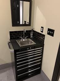 Since the garage is mainly used as a childrens playroom it was important for the homeowner to have enough glass windows on the garage door to allow natural light in but strong enough to support children. Toolbox Sink With Black Subway Tile And Black Grout Garage To Living Space Garage Bathroom Ideas Garage Bathroom