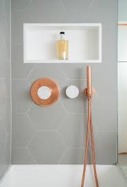 Black hexagon tile in bathroom. This Bathroom Features Copper And Marble Fixtures Next To Light Gray Hexagon Tiles Trendy Bathroom Tiles Small Bathroom Remodel Bathrooms Remodel