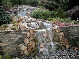 Natural rock retaining wall in a garden. Landscape Design Custom Masonry Retaining Walls