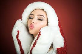 Sexy santa ragazza carina donna in cappello di babbo natale e guanti di  pelliccia bianca manda un bacio d'aria grande novità
