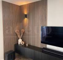 Lattenwand achter de tv gemaakt van houten wandpanelen