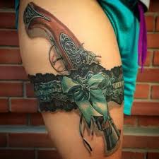 In between guns resting on flowers around belly button. 40 Awesome Pistol Gun Tattoos Design Ever Made