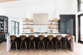 A dark and rich floor with bright white furniture and cabinets lays down the foundation of this cozy and inviting kitchen. Black White And Wood Kitchen With Brass Hardware Studio Mcgee 1 39 34 Pm The Identite Collective
