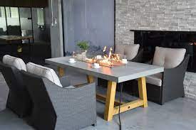 Brown composite dining height deck top. The Elementi Workshop Dining Table Combines A Cast Concrete Dining Surface With A Lava Rock Propane Fire Featu Outdoor Fire Pit Table Fire Table Fire Pit Table