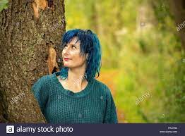 Download This Stock Image Portraits Of A Blue Haired Woman In A Blue Jumper Leaning Against A Tree Trunk Pkjh53 From Alamy S Blue Jumper Hair Beauty Dress