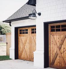 Black And White House With Wood Garage Door Wood Rustic Farmhouse Garage Doors White Siding Black Roof Garage Door Design Farmhouse Exterior Modern Garage Doors