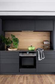 This black kitchen is paired with a lot of wood accents and we're loving the rich and masculine energy that it's giving off. Charcoal Grey Kitchen With Wall Units And Wooden Splashback Kitchen Splashback Designs Small Kitchen Units Charcoal Kitchen