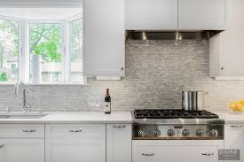 Still, others add modern mosaic backsplash usually in tones of blue or gray paired with a plain colored countertop. Boston Transitional Kitchen Grey Peninsula Divine Design Build