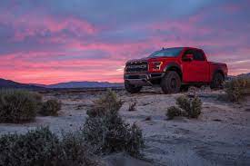 Raptor Parked On Sand With Sun Setting In Background Ford Raptor Ford Trucks Pickup Trucks