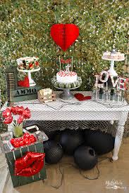 Themed valentine decorations like these table cloths drape the tables and the red plaid blanket draped over the chair adds warmth and texture. Fall In Love With These 24 Valentines Party Themes