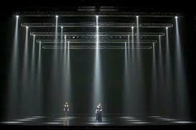 Lights Beaming Down In Ordered Pattern Surrounded By Trees Which Are Not Following The Same O Lighting Design Theatre Stage Lighting Design Set Design Theatre