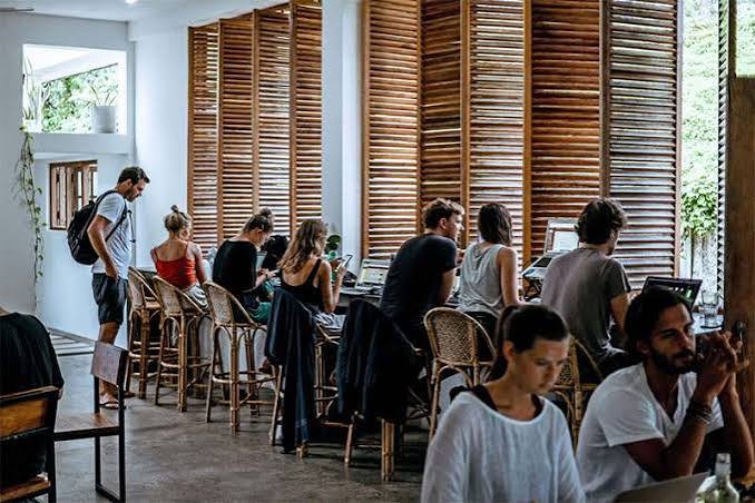 People working from a laptop-friendly cafe
