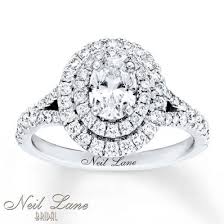 A Double Halo Of Round Diamonds Beautifully Encircle The C Pear Shaped Diamond Engagement Rings Set Moissanite Engagement Ring White Gold Diamond Wedding Bands