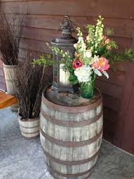 Entrance Centerpiece Atop A Whiskey Barrel With A Lantern Our In House Floral Designer Has A Great Talent Barrel Decor Front Porch Decorating Porch Decorating