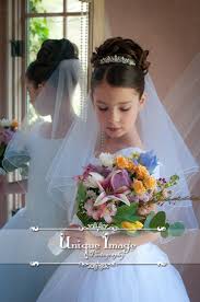 Here the proposal is to leave the hair a little below the shoulders very natural slightly wavy and create a very subtle half ponytail that intertwines. Pin By Unique Image Photography On First Communion Portraiture Communion Veils First Communion Hairstyles First Communion Veils