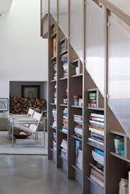 These Clever Tricks Transform That Awkward Space Under Your Stairs Staircase Bookshelf Stair Bookshelf Under Stairs Design