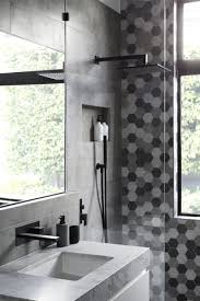 Grey bathroom with black hardware. Matte Black Accents Add Sophistication To This Grey And White Bathroom Bathroom Interior Design Gray And White Bathroom Black Tile Bathrooms