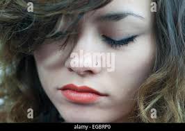 Glamorous Thai woman with beautiful eyes eats skillfully noodle soup with a  pair of wooden chopsticks and a Chinese soup spoon Stock Photo