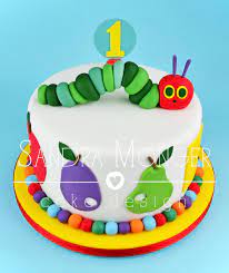 Make the caterpillar face by melting and piping white chocolate, using smarties for the eyes and mouth. Hungry Caterpillar Birthday Cake Hungry Caterpillar Cake First Birthday Cakes Cake Designs Birthday