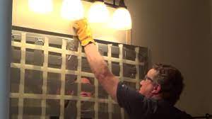 Next, gently slide the tip of the crowbar between the wall and one of the shims, and while your assistant holds the mirror steady, begin prying until you can feel some slight movement. How To Remove A Glued Bathroom Mirror From The Wall Youtube