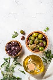 Olives In Wooden Bowls And Olive Oil Bottle On White Background