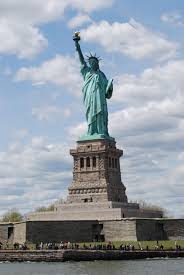 An inscription on a bronze plaque sits at the bottom of the monument. The Statue Of Liberty Is A Colossal Neoclassical Sculpture On Liberty Island In The Middle Of New Y Statue Of Liberty New York City Vacation Freedom Sculpture
