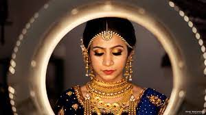 Bridal Makeup Bride Wearing A Gold Choker With A Gold Eyeshadows And Red Lips Indian Bride Makeup Indian Wedding Photography Couples Bridal Photography Poses