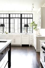 It features a timeless design and it has a gorgeous bay view! Beautiful White Kitchen With Black Frame Windows Home Kitchens Kitchen Remodel Kitchen Design