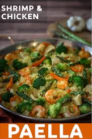 This Delicious Shrimp And Chicken Paella Is Made With Broccoli Carrots And Asparagus Then It Is Topped With Paella Recipe Easy Chicken Paella Paella Recipe