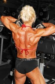 امرأة كمال أجسام شقراء عضلية للغاية تقذف عضلاتها على ظهرها وذراعيها في صالة  الألعاب الرياضية أمام الجهاز صورة الخلفية والصورة للتنزيل المجاني - Pngtree