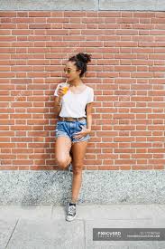 If the ladder is not to slip, which one of the following must be true? Young Woman Leaning Against A Brick Wall Drinking Orange Juice Awaiting Person Stock Photo 173782160