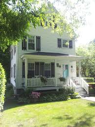 Chic cottage home features taupe siding framing a turquoise front door flanked by sidelights. Modern Pergola Over Garage Door Novocom Top