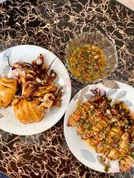 Serveres med skiver af agurk og friske korianderblade for at få en afkøling i munden. Sotong Bakar Thai Sos Sedap Padu Memang Terangkat