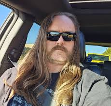 Please somebody tell me, who is the guy to the left in this photo with  Lemmy? Somebody told me it was Phil "philty" Taylor, but it does not look  like him at