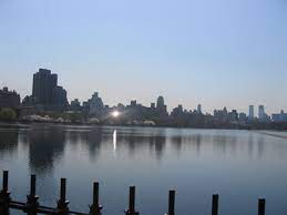 Central park west buildings over lake. Reservoir Central Park