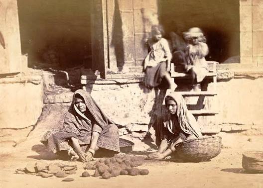 Old picture of Madras women carrying cow dung.