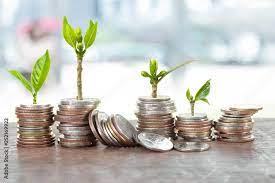 Financial planning, Money growth concept. Coins with young plant on table  with backdrop blurred of people walking in city town. Stock Photo | Adobe  Stock