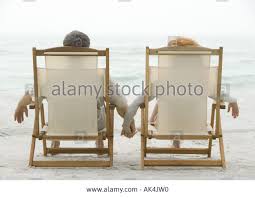 Stock Photo Couple Sitting In Beach Chairs Holding Hands Rear View Beach Chairs Stock Photos Rear View