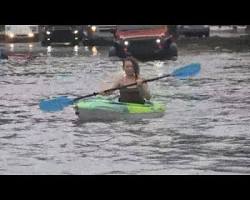 Image of someone kayaking down a flooded street