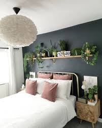 Need to up your bedroom's pizzazz? Picture Of A Stylish Small Bedroom With Green Panels On The Wall A Grey Upholstered Bed Neutral Bedding Layered Rugs And Potted Plants
