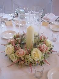 Hurricane Vase With Floral Surround Candle Standing In Sand Wedding Floral Centerpieces Wedding Centerpieces Candle Centerpieces