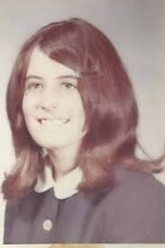 What is the age of the photo in the 1973 postcard?