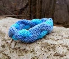 Стоковая итальянская пряжа в бобинах. Knitted Bracelet The Waves Of Sea And Love