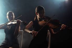 Maybe you would like to learn more about one of these? Female Musicians Playing Classical Music On Violins On Dark Stage With Smoke Free Stock Photo And Image