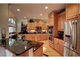 Get beauty and durability without sacrificing affordability with kitchen cabinet refinishing. Kitchen Stainless Steel Dark Granite Counter Tops Light Wood Cabinets Lighter Wood On Floor White Light Wood Cabinets Dark Kitchen Dark Kitchen Cabinets