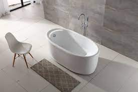 Oval soaking tub with chrome corner faucet is seated inside patterned tile enclosure between twin this soaking tub employs a whirlpool system, for a massaging experience. China Woma Acrylic White Soaking Bath Seated Cupc Free Standing Tub 59 Q132a China Freestanding Bathtub Freestanding Bathtubs
