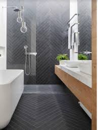 Given the dark grey tiles and wall, the white vanities and brick wall, the cool drama of this room keeps rolling. What Bath Vanity Color With Dark Grey Flooring