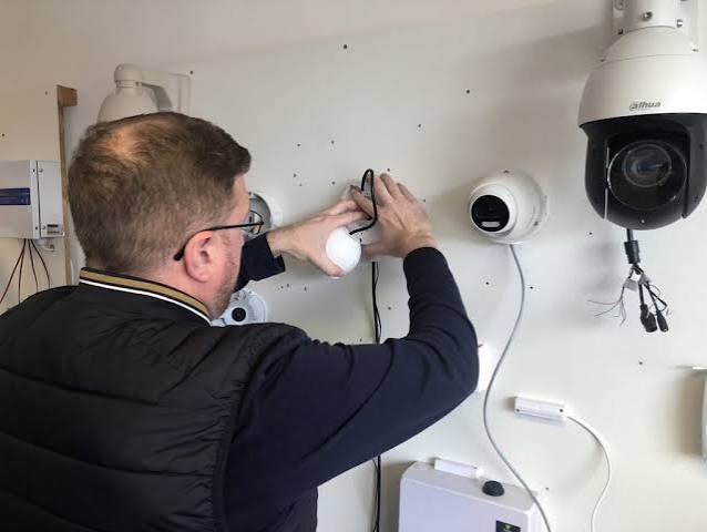 Certified security technician installing a CCTV camera