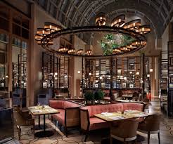 Colony Dining Room With Vaulted Ceilings A Massive Circular Light Fixture Seating And Metal Room Partition Hotel Interior Design Restaurant Restaurant Design