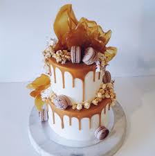 2 Tier White Buttercreme Caramel Drip Cake With Macarons Popcorn Cascading Toffee Shards Cake Drip Cakes Drop Cake